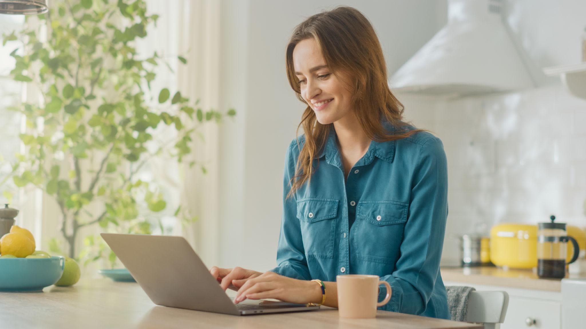 Symbolfoto (KI-generiert): Eine etwa 30-jährige Frau sitzt zu Hause am Laptop und beschäftigt sich mit der Online-Partnersuche.
