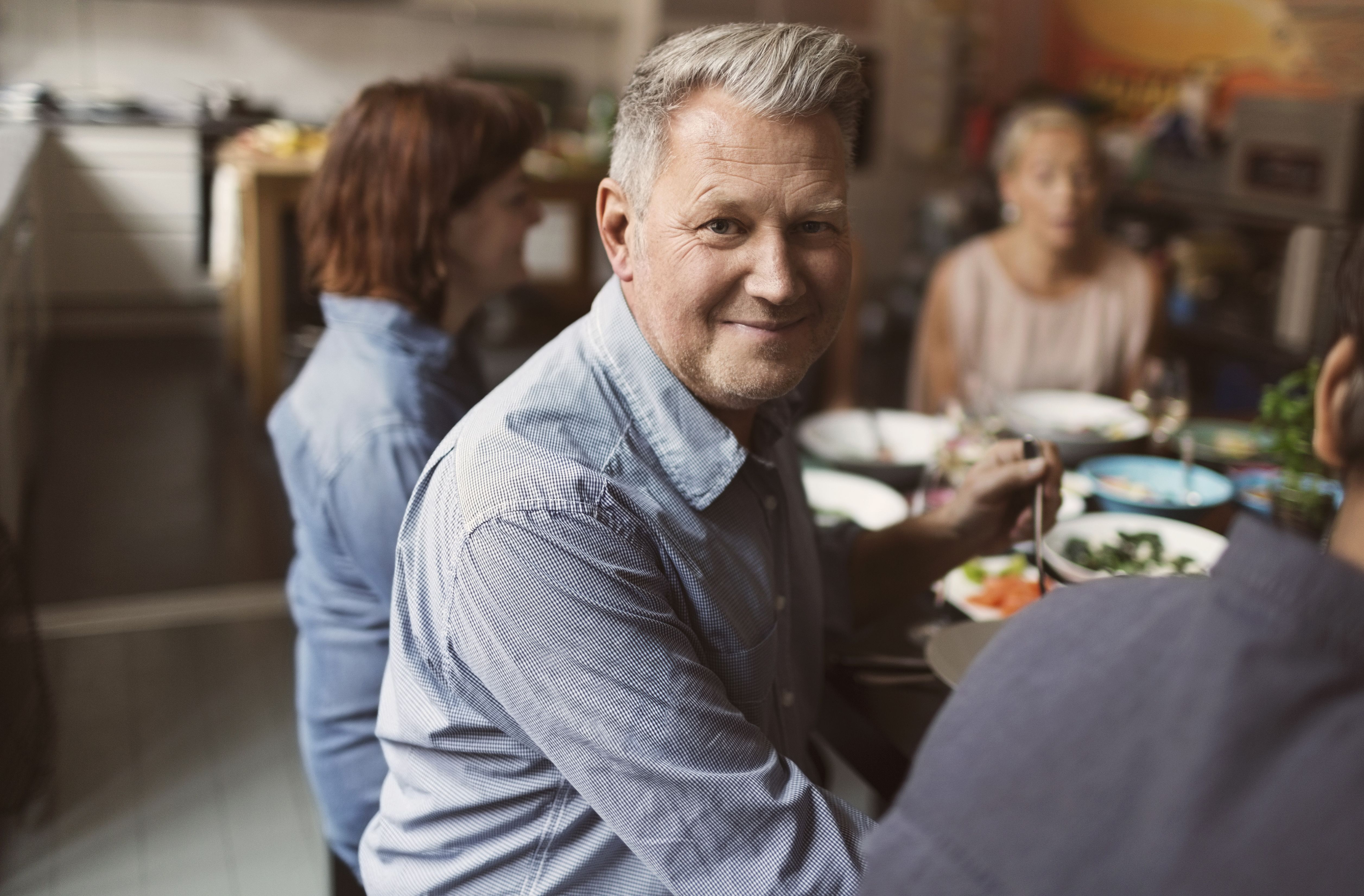Glücklicher 40-jähriger Single-Mann lächelt entspannt in die Kamera.