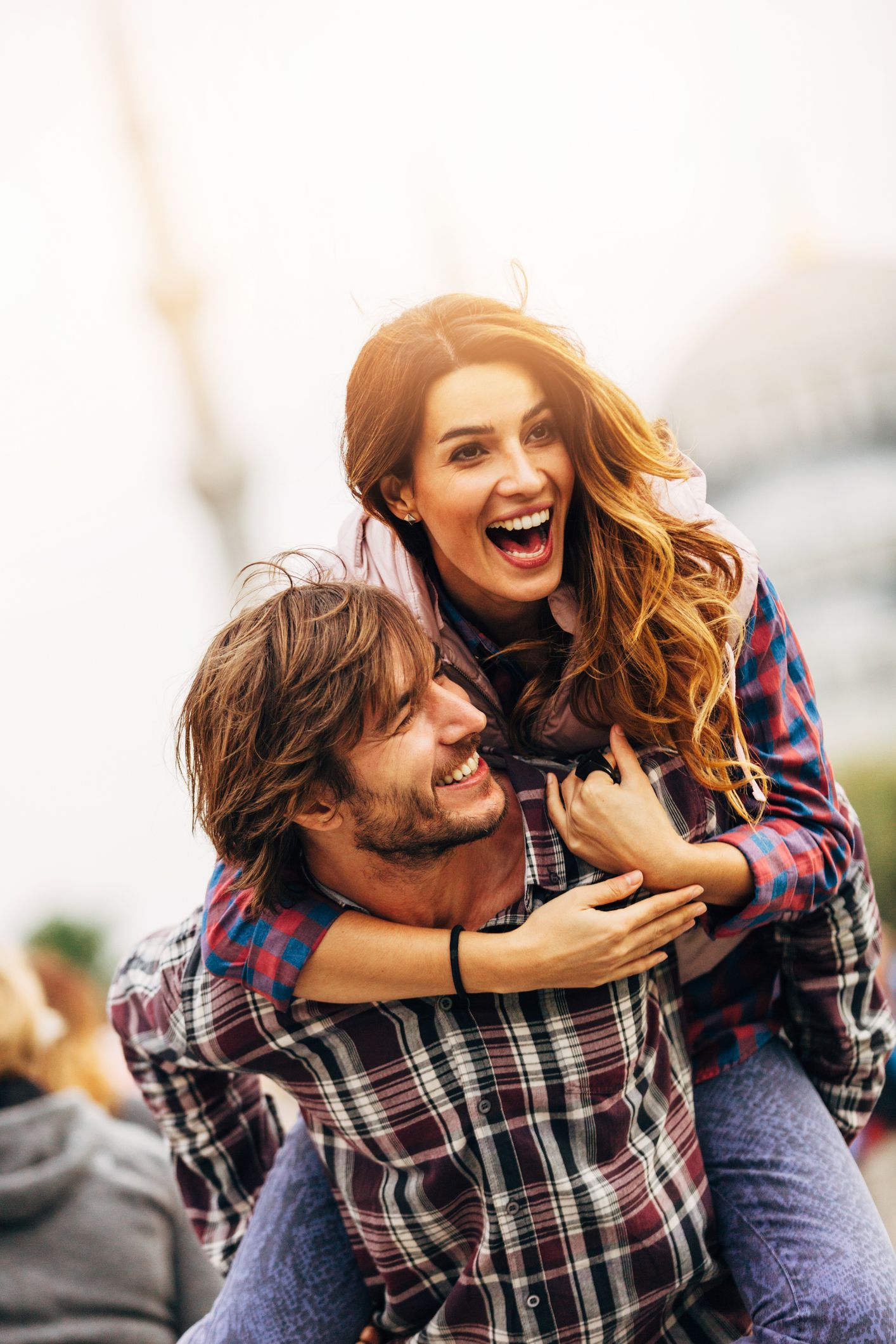 Junger Mann und junge Frau lachen gemeinsam nach dem Kennenlernen über eine seriöse Dating-Plattform und bauen eine langfristige Beziehung auf.