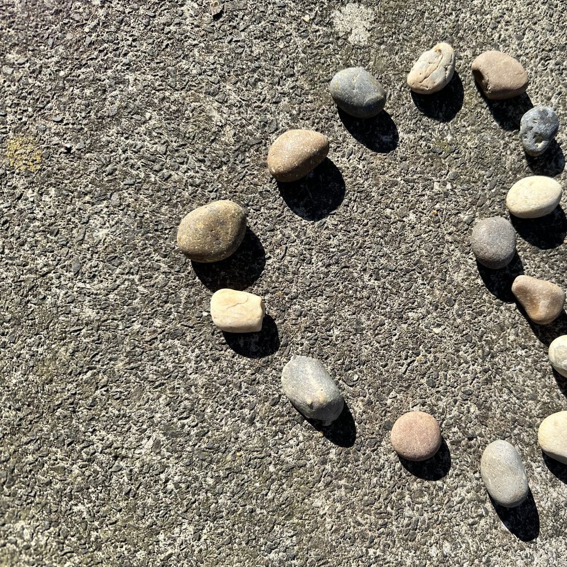 Kleine Steine, die am Sandstrand ein Herz bilden, als Symbol für eine Begegnung ab 50, eine dauerhafte Beziehung und geteilte Liebe.