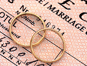 Heiratsvermittlung: Zwei Ringe auf einer Heiratsurkunde