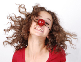 Liebe finden mit Witz: Frau schaut freudestrahlend mit Clownsnase