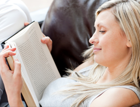 Klassiker der Literatur: Frau relaxt auf Couch und liest ein Buch