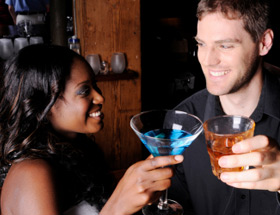 Mann und Frau stoßen auf einen Drink in der Bar an