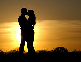Monogam leben: Paar küsst sich im Sonnenuntergang