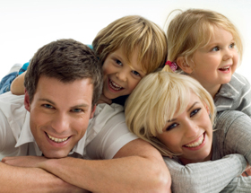Patchwork-Familie: Mann und Frau liegen mit ihren Kindern auf dem Boden