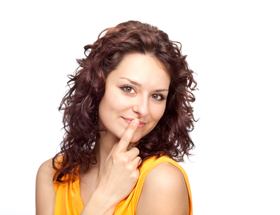 Schummeln beim Online-Dating: Frau hält sich den Zeigefinger vor den Mund