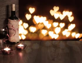 Wine on a table with candles in the background.